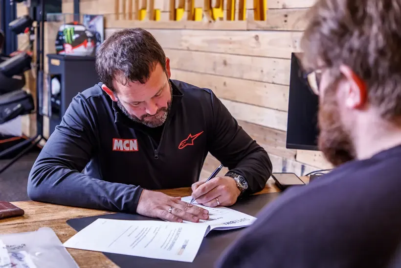 MCN team member signing papers for motorcycle purchase