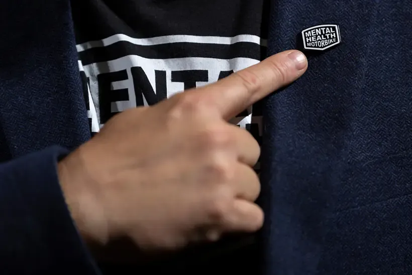 Pointing to a Mental Health Motorbike pin badge