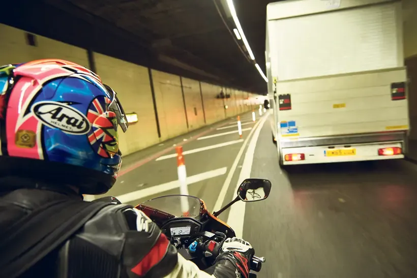 Motorcycle rides through a tunnel in traffic